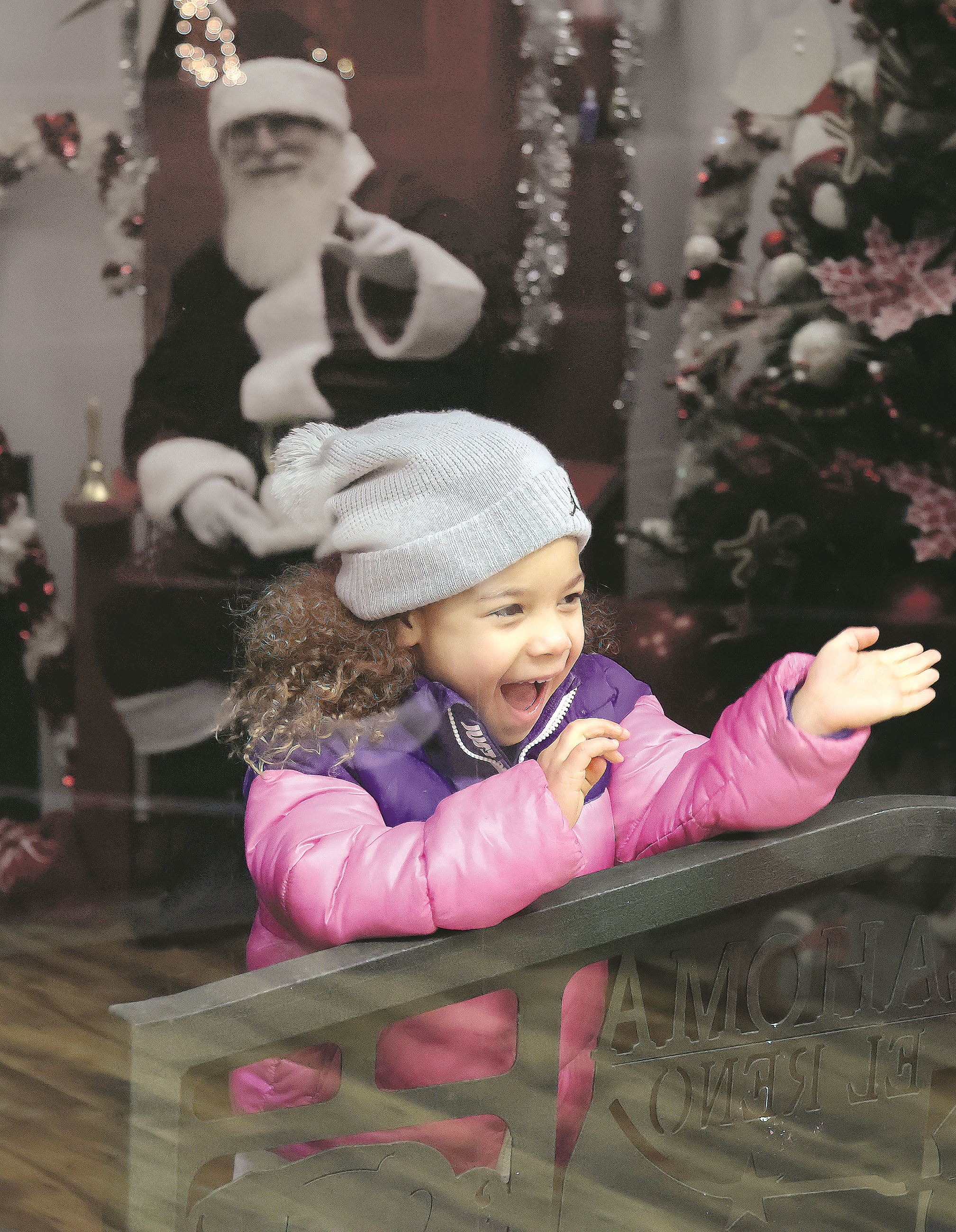 Girl waves through window at Santa Claus 1